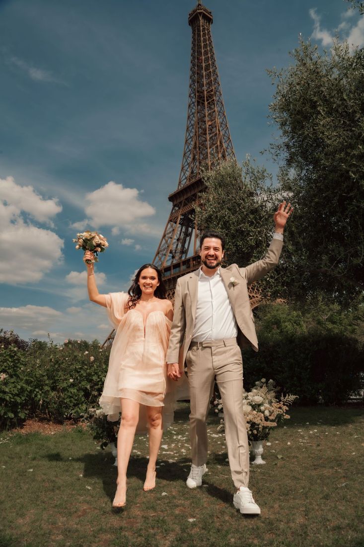 Casal comemorando o casamento em frente à Torre Eiffel